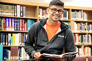 A male student holding a book
