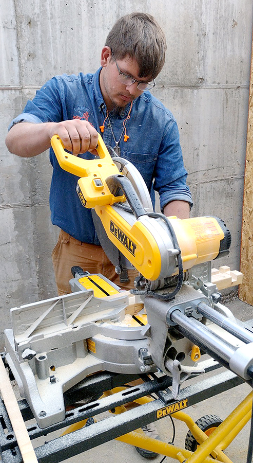 Photo of construction core student working with circular saw