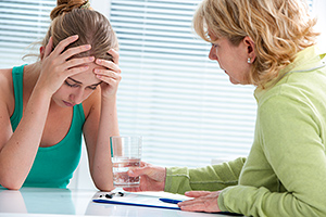 treenage girl suffering with depression in a conversation with a therapist