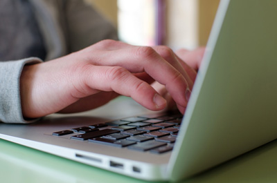 Hands typing on laptop