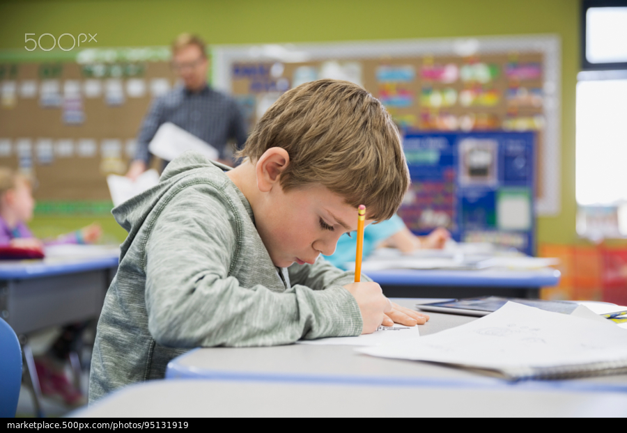 Young boy writing at table
