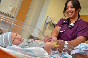 Photo of female nurse and infant in hospital 