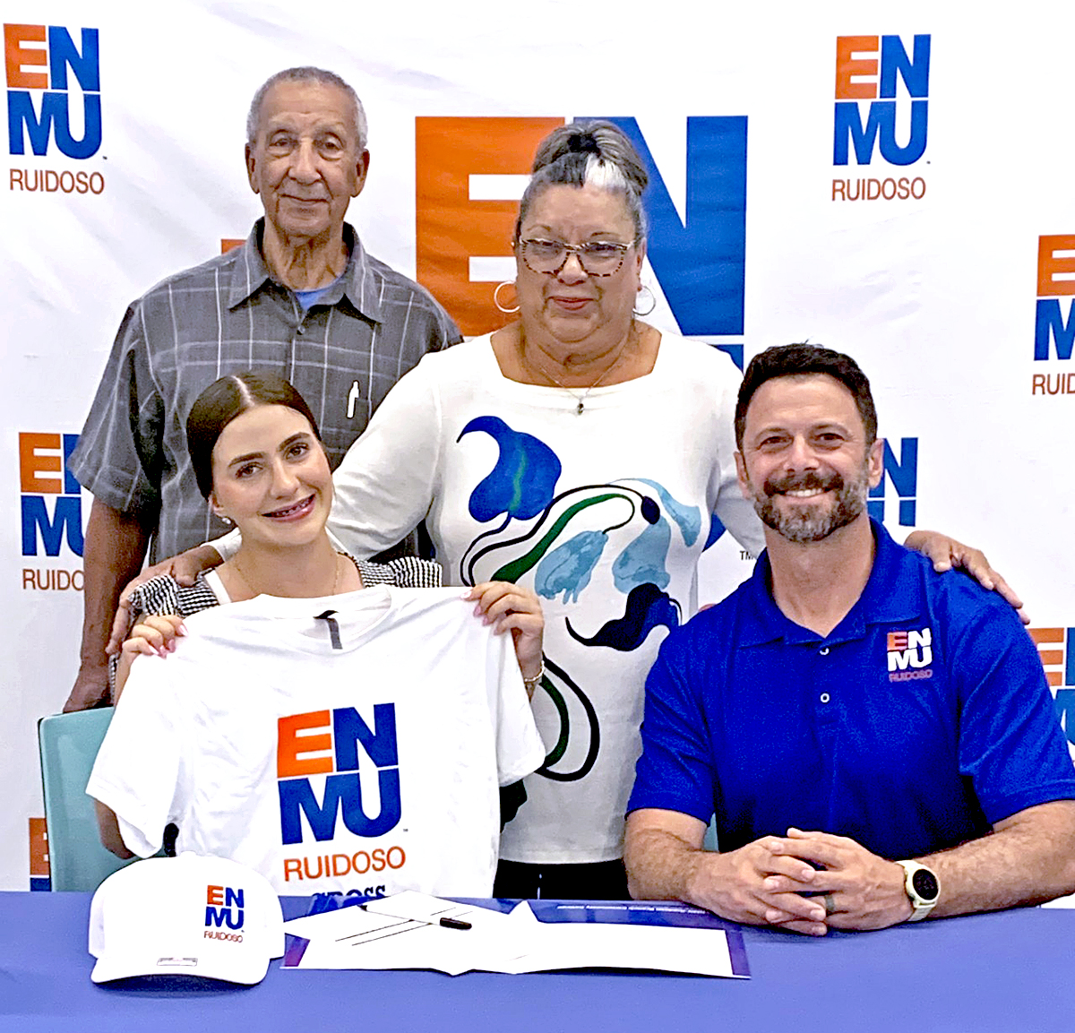 Photo of Caydence Holly Woods with Cross Country Coach Micah Bray with Caydence's parents, Virgil and Sylvia Woods standing in back