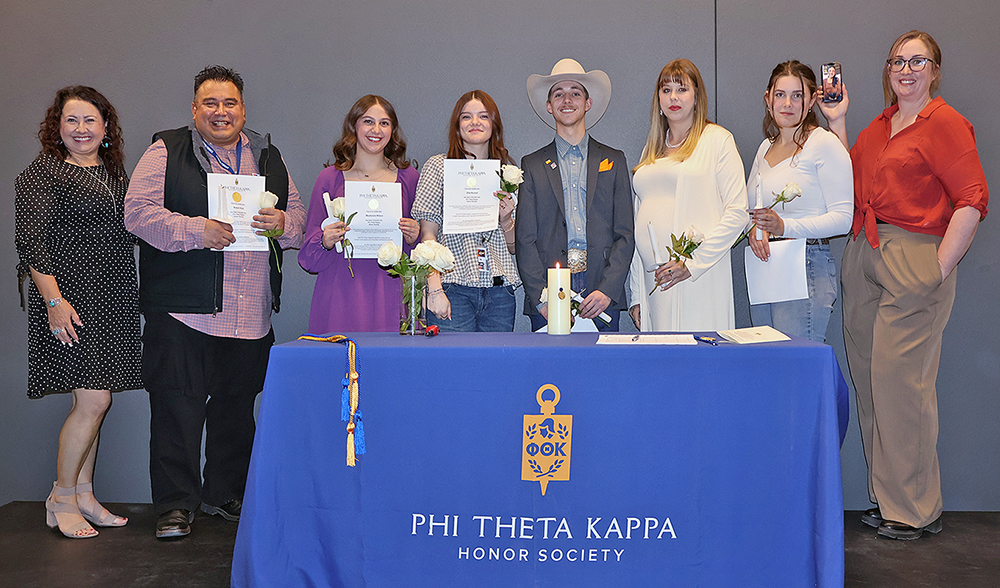 Photo of Cleo Mow, Robert Ruiz, Mackenzie Wilson, Ella Hovrud, Cole Hanshew, Jesse Dentler, Madalyn Heidbreder and Destiny Hixon, all standing behind table with blue PTK table cloth