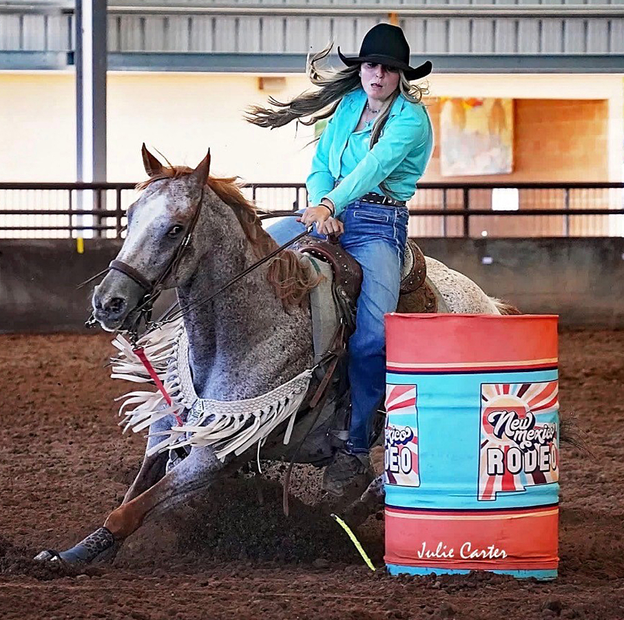 Photo of Savannah Fresquez during barrel racing competition, as her horse rounds the barrel