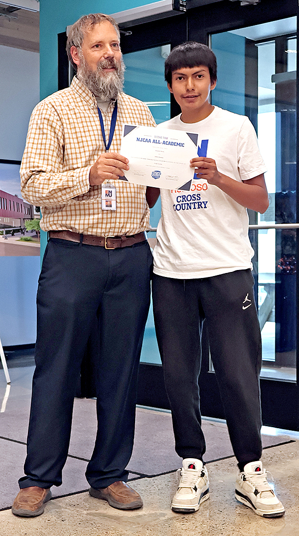 Photo of ENMU-Ruidoso President Dr. Ryan Trosper presenting NJCAA certificate for All-Academic achievement to Cross Country athlete Brayden Rocha